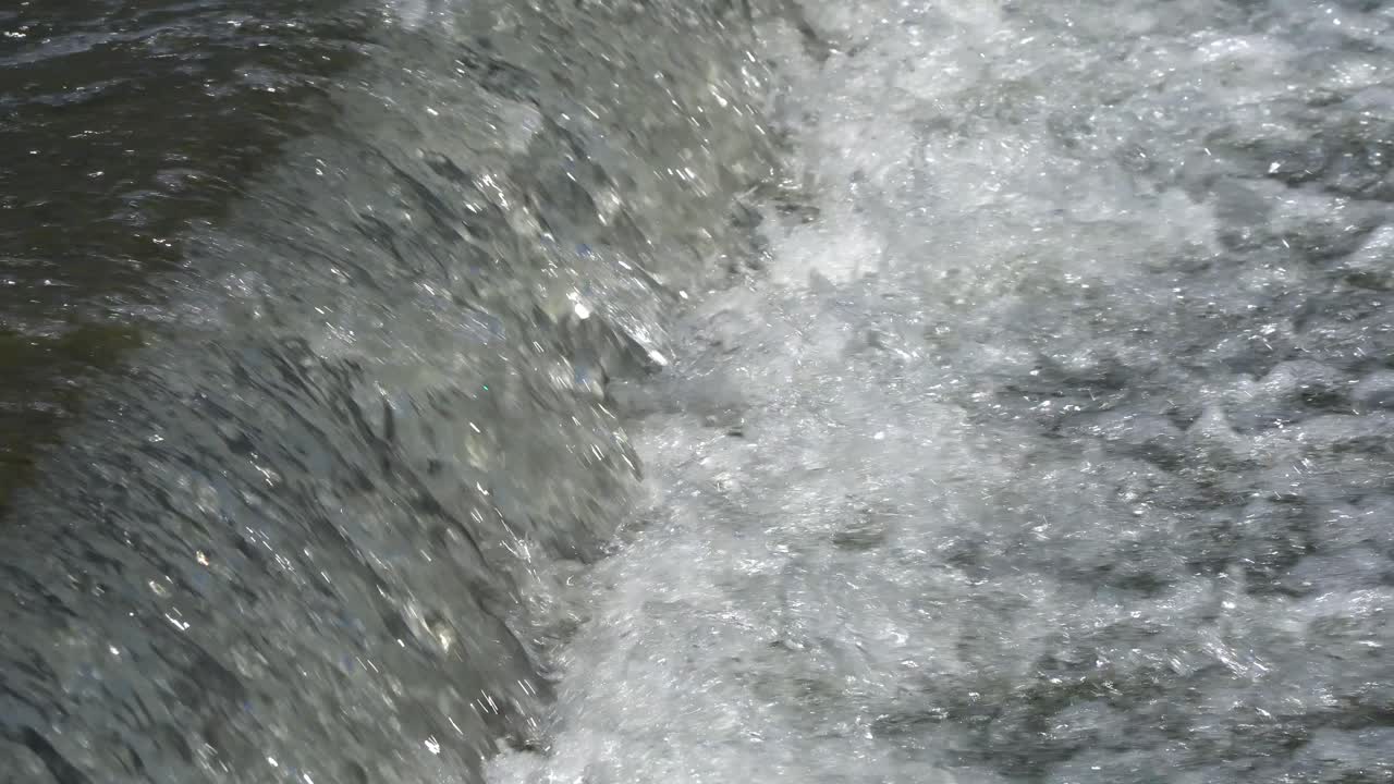 Water stream running down the slope, rapid water motion waterfall
