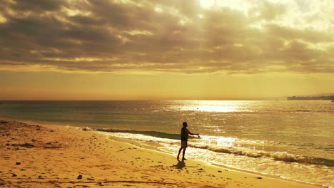 Pescador-Tratando-De-Atrapar-Un-Pez-En-La-Playa-En-Hawaii-Mientras-Disfruta-De-La-Hermosa-Puesta-De-Sol---Tiro-Aéreo