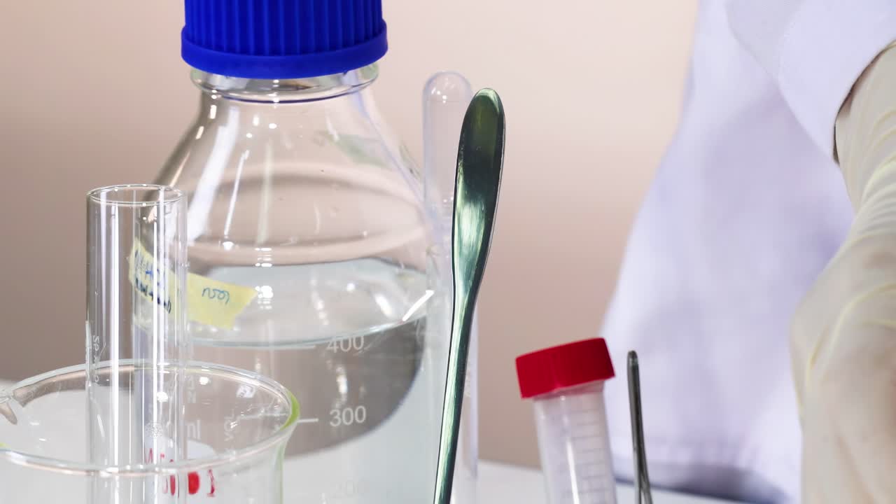 A scientist carefully manipulates glassware and solutions in a laboratory setting, showcasing precision and technique.