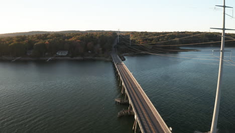 aerial flyover footage at causeway with powerlines leading into mainland at yarmouth, usa