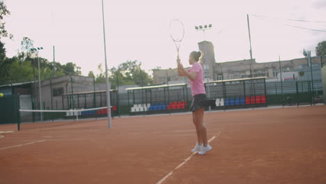 Tenis-Profesional-Determinado-Jugador-Deportivo-Chica-Golpeando-La-Raqueta-En-La-Pelota-En-La-Cancha-Roja-Profesional-Durante-El-Partido-Al-Aire-Libre-En-Cámara-Lenta