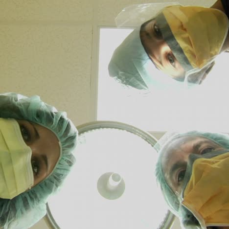 Surgeons-look-down-on-a-patient-and-use-instruments-in-this-POV-shot-1