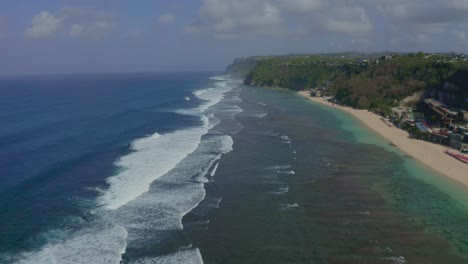 there are many low rise houses on top of big mountains in front of melasti bali beach