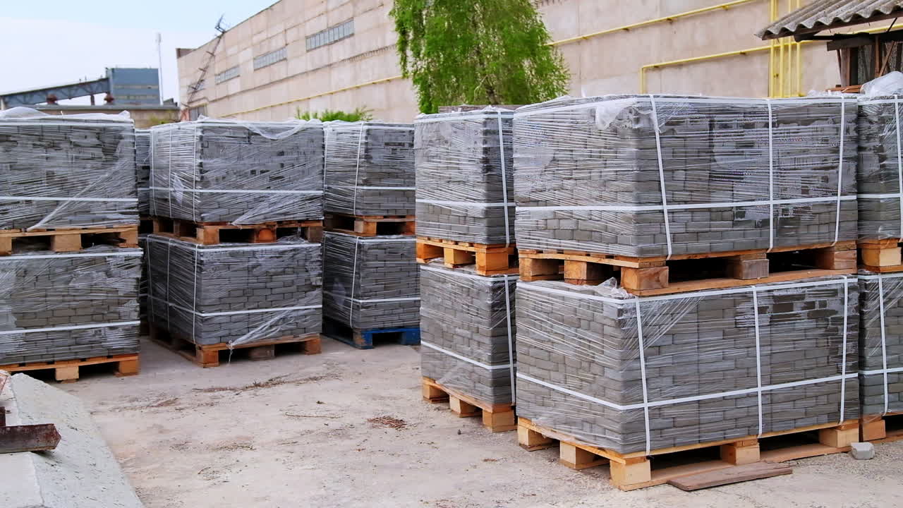 Large packs of grey bricks left outside at the construction zone. Site prepared for a new building with materials for it.