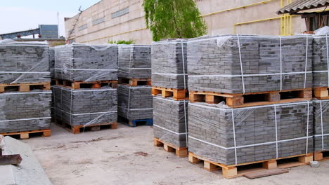 large packs of grey bricks left outside at the construction zone. site prepared for a new building with materials for it.