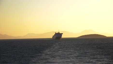 Ferry-Navegando-En-Las-Aguas-Del-Mar-Jónico-En-Los-Rayos-Del-Sol-Poniente,-Con-El-Telón-De-Fondo-De-Las-Islas-Griegas