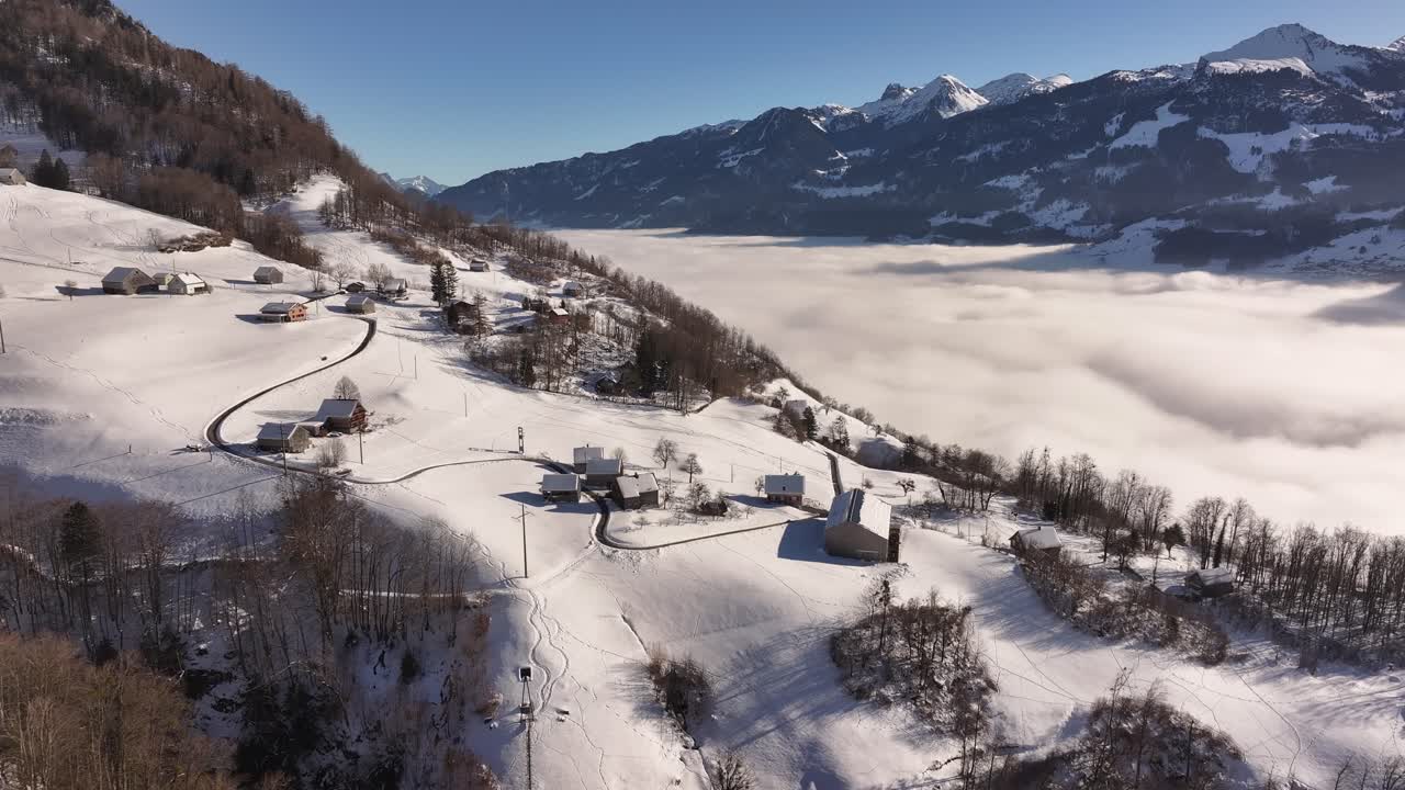 Winter in the village of Weesen on the shore of Lake Walensee. Snow-covered hills of the Alpine nature. Schweiz, aerial