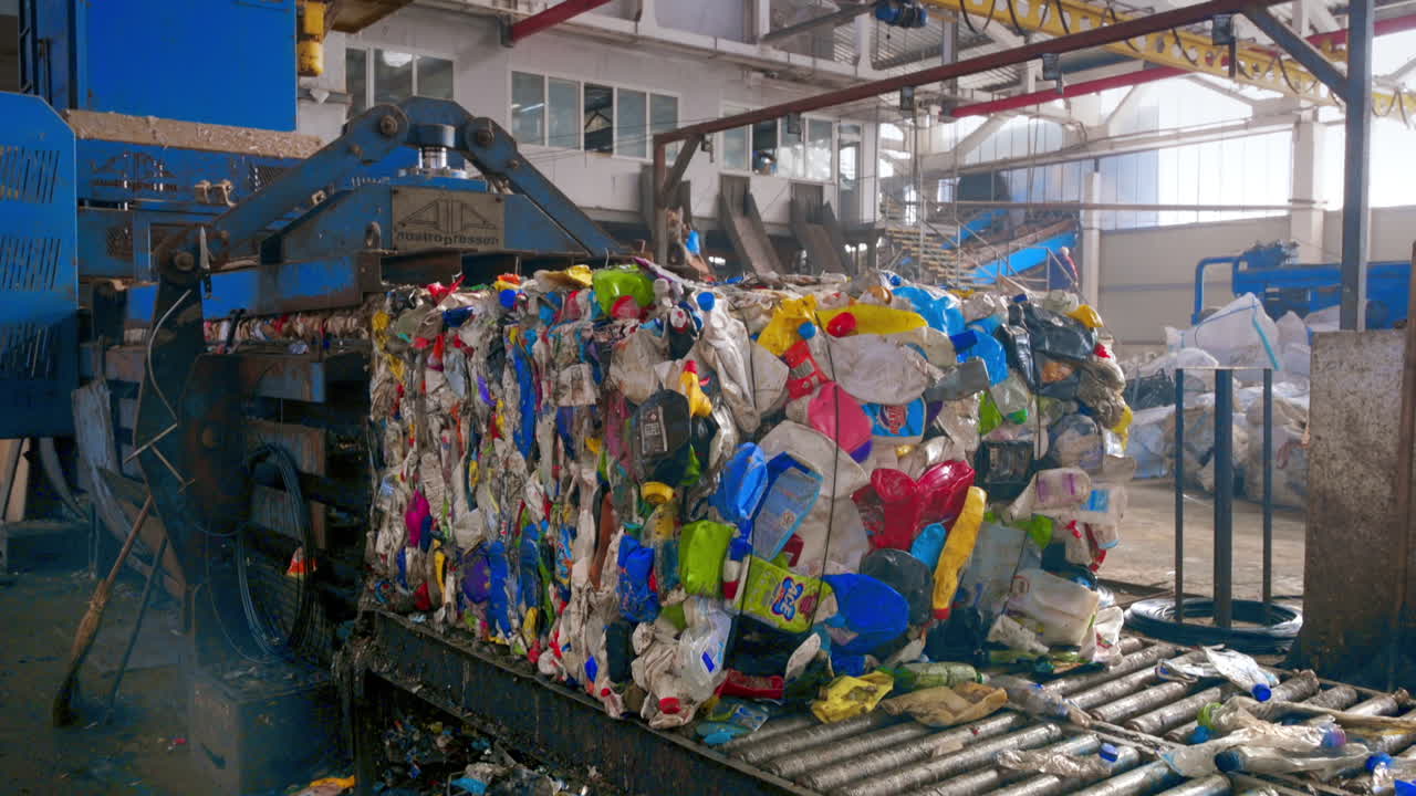 Pressing machine making a cube of plastic garbage at waste sorting plant