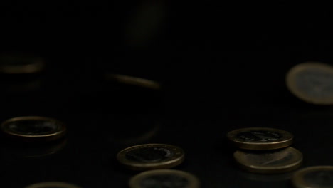las monedas de euro que caen sobre una superficie negra
