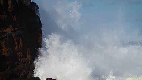 large waves roll into the coast of hawaii in slow motion and break along a craggy coast 5