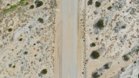 Toma-Aérea-Manteniendo-El-Marco-Central-De-La-Carretera-Del-Desierto-Mientras-Avanza