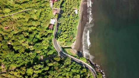 bird eyes view via drone of the highway beside the beach and the waves wash the coast in 4k and 30 fps