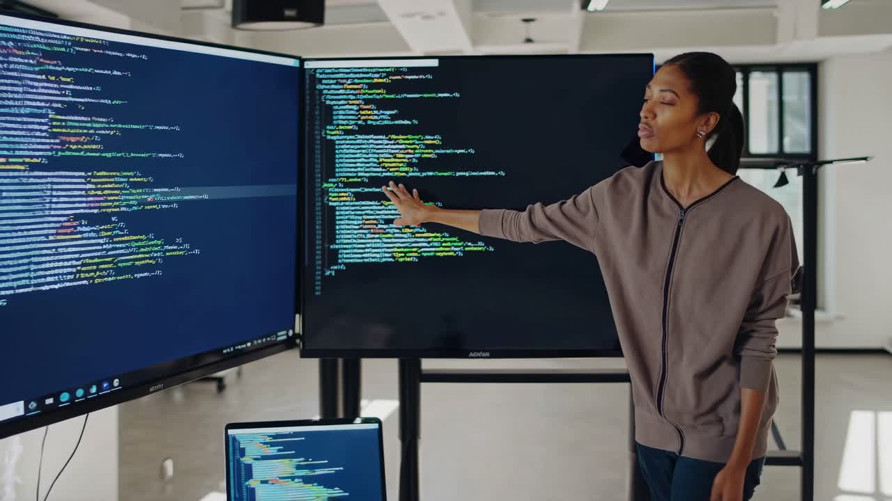 Woman Presenting Code on Large Display Screens