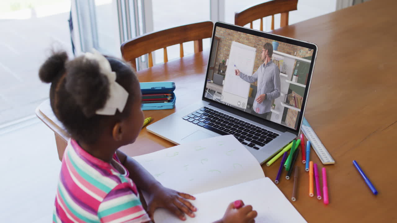 African american girl sitting at desk using laptop having online school lesson