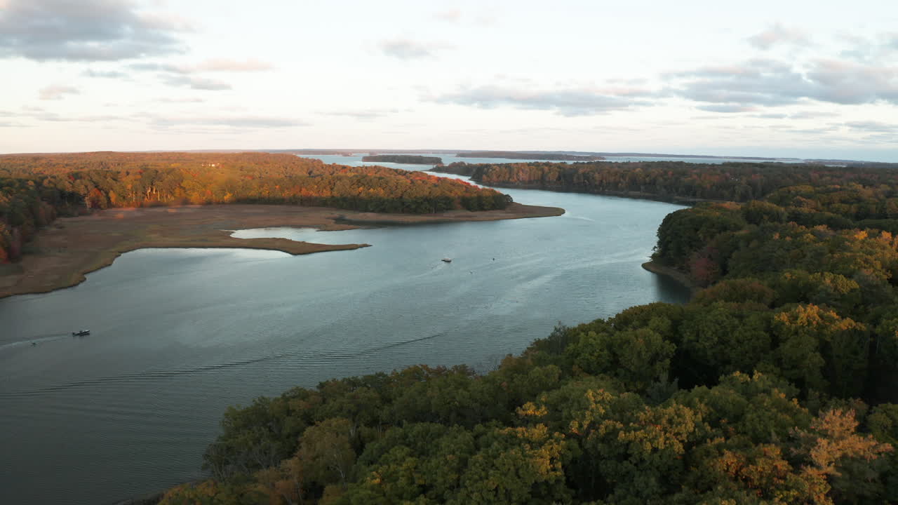 Riprese aeree in sorvolo alto che dominano alberi lussureggianti, rivelando lo sbocco del fiume nell'oceano presso il Royal River, isole costiere, Maine