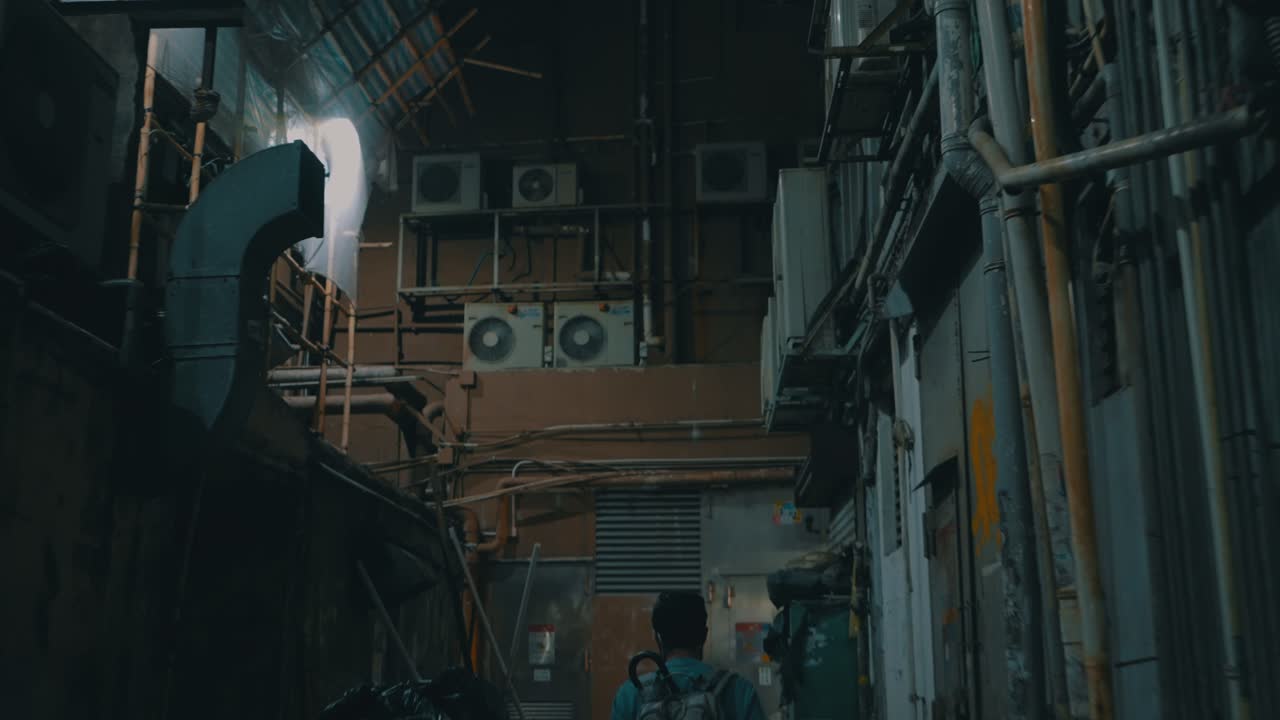 도시에서 밤에 오싹하고 더러운 작은 거리를 걸어가는 남자