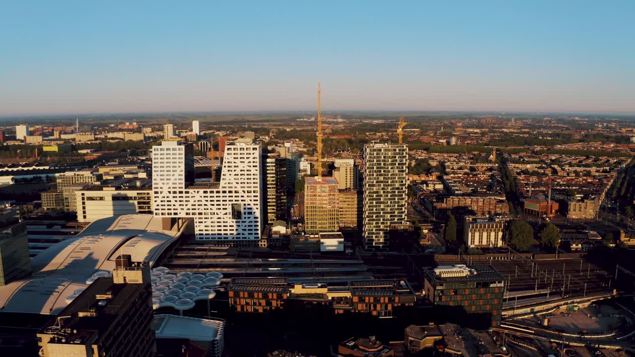 Aerial drone tracking shot of central train station and city centre in Utrecht with the modern buildings surrounding it, The Netherlands