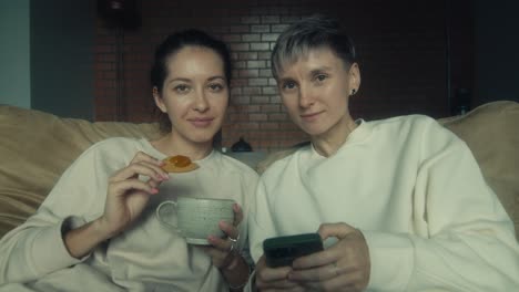 two women relaxing on a couch