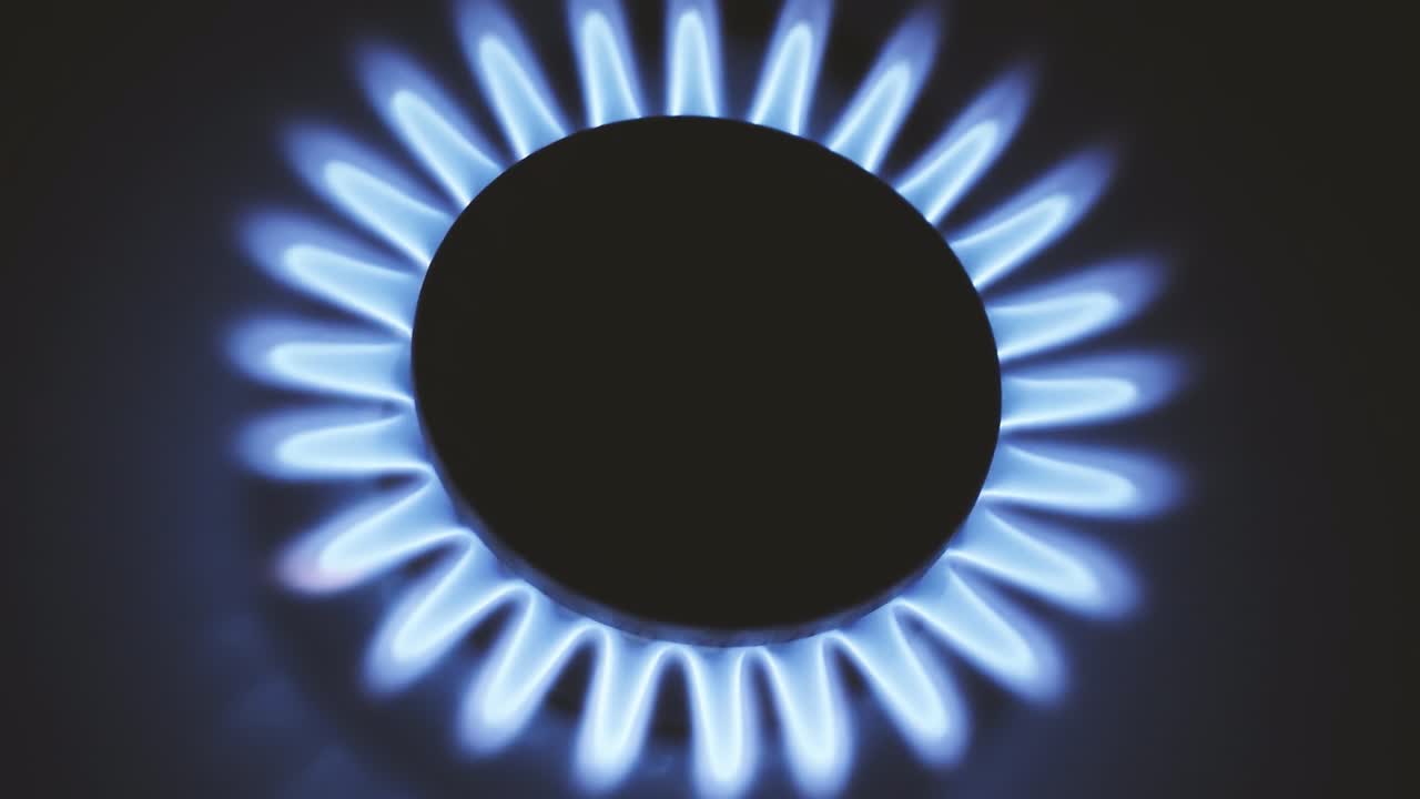 горящая газовая плита, синие пламя макро крупный план в темноте на черном фоне. 4k сырое видео с плавным движением камеры.