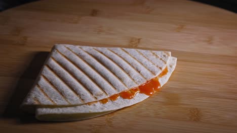 poner tortillas de dos cuartos con salsa de naranja en una mesa de madera