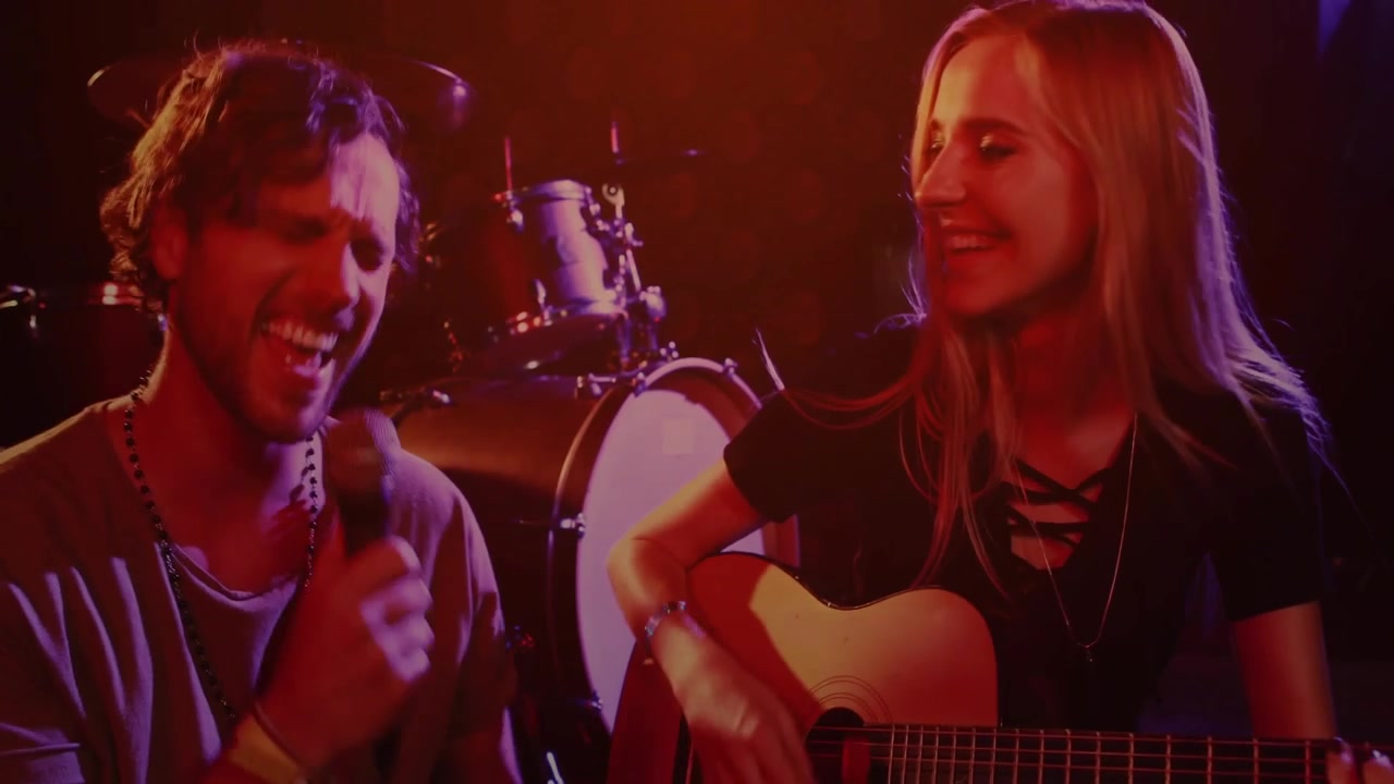 Una strimpellata di chitarra avvia un'overlay pulsante, la telecamera si allontana, mostrando un duo che canta, strimpella e crea un legame.