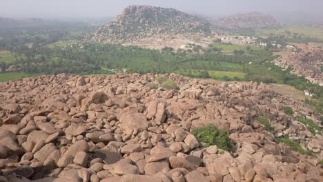 lone man is lost among the giant stacks of huge stones in hampi, india