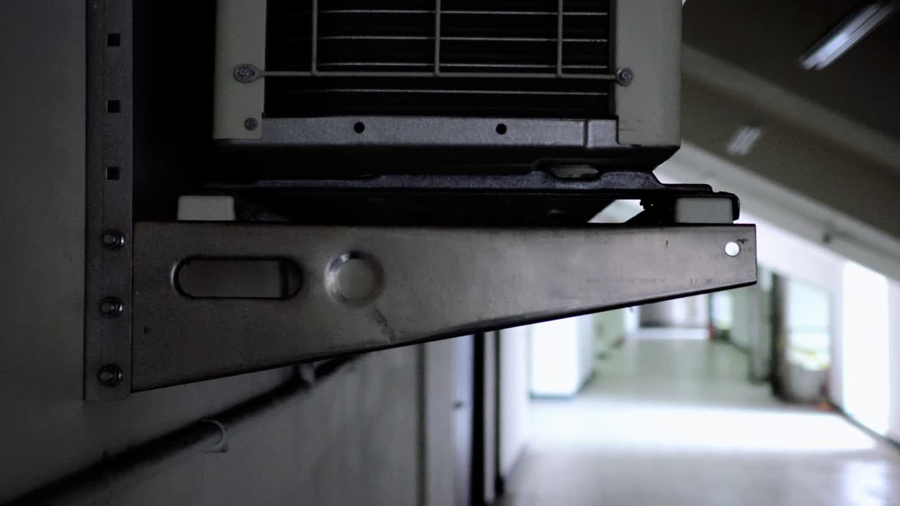 커다란 에어컨 압축기가 벽에 매달려 있습니다. 대상은 왼쪽에 있습니다.