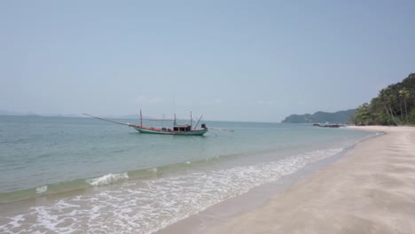 Serena-Playa-Paradisíaca-De-Arena-Blanca-Con-Un-Barco-Anclado-En-Tailandia