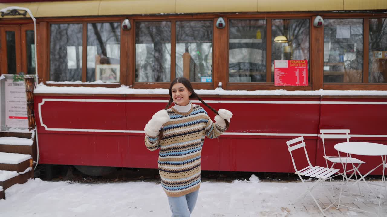 una mujer disfrutando de un día de invierno en una zona de café nevada.