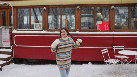 woman enjoying winter day in a snowy cafe area.