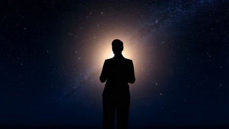 silhouette of a person against a starry galaxy sky