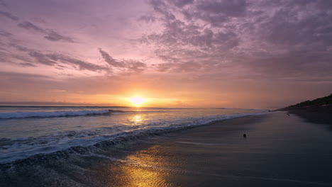 el atardecer dorado sobre las tranquilas olas del océano, el dramático paisaje de nubes en el fondo.