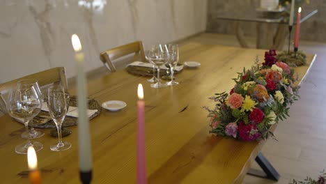 Wedding table set with floral centerpiece, candles, and fine glassware