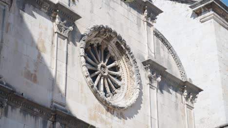 close up on a large beutiful renaissance style window of the franciscan monastery museum in old town of dubrovnik croatia near the entrance gate pile on a bright summer day