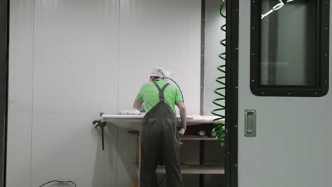 worker sanding and finishing a surface in a manufacturing facility