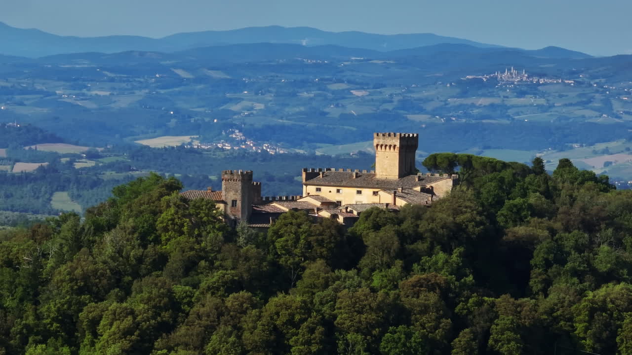 Ripresa con drone teleobiettivo che circonda un castello medievale nelle colline del Chianti in Toscana, Italia.
