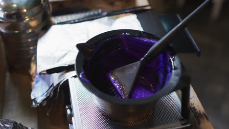 black bowl full of purple hair dye on table at hair salon