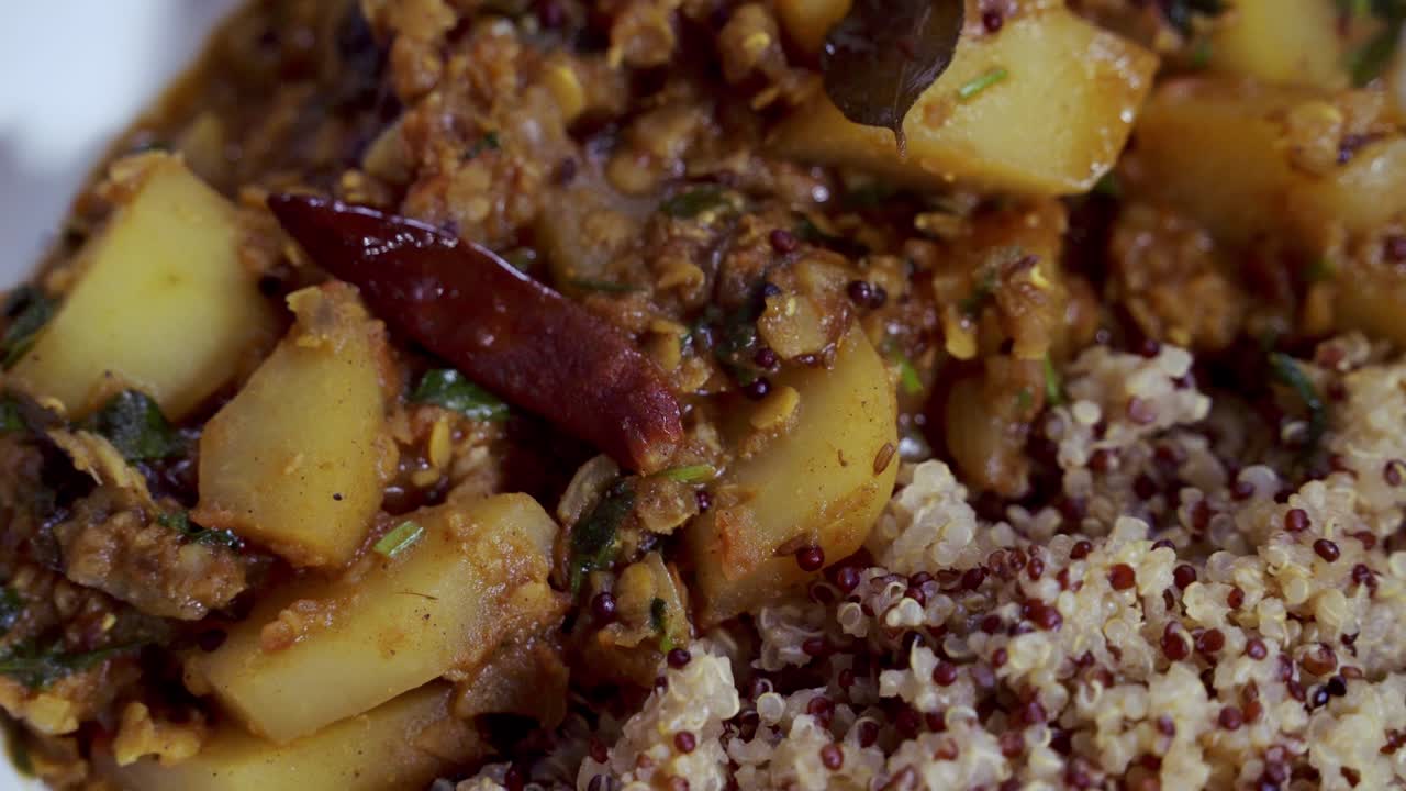 vista aérea del plato de curry de papaya girando en una plataforma dentro de un plato blanco con pimienta de chile a la vista