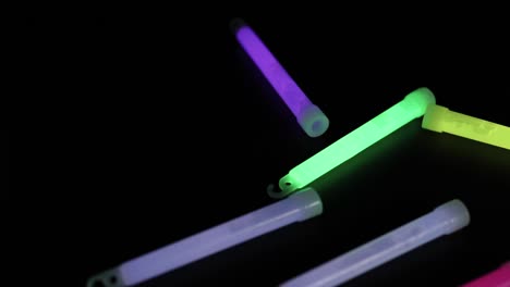 palos brillantes de colores siendo arrojados en la oscuridad