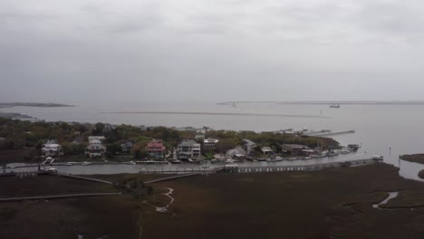 Aerial-low-dolly-shot-of-Shem-Creek-along-Charleston-Harbor-on-a-hazy-day-with-low-visibility-in-Mount-Pleasant,-South-Carolina