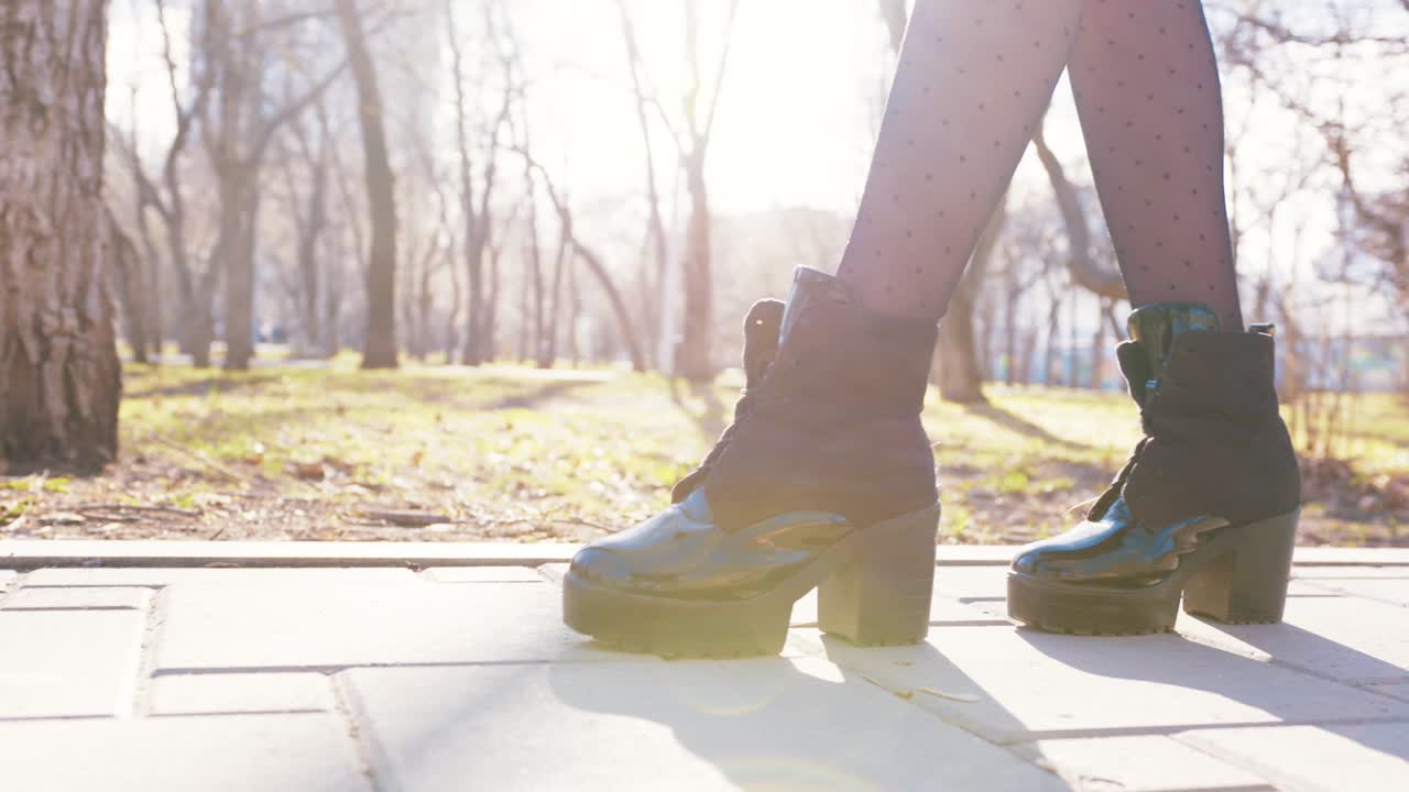 스타일리시한 부츠를 입고 공원에서 고 있는 여자