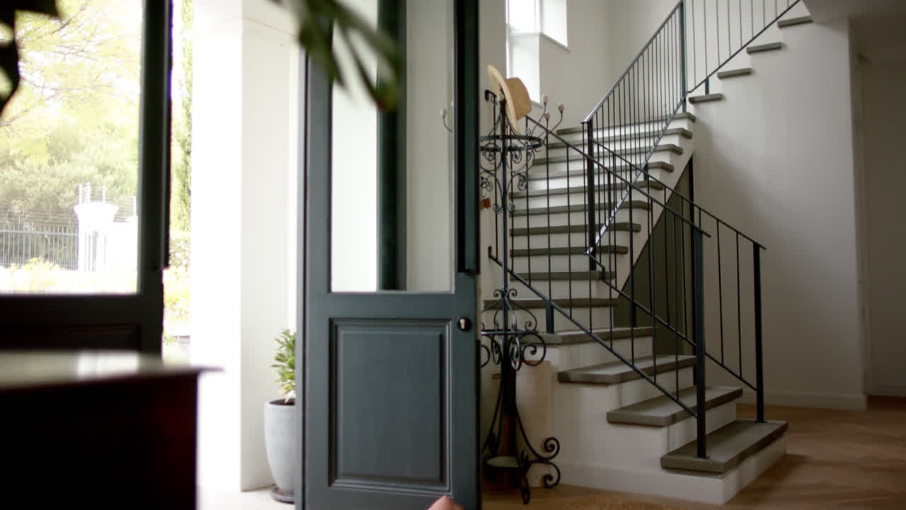 vista general de la escalera en el hogar con la puerta delantera abierta, cámara lenta