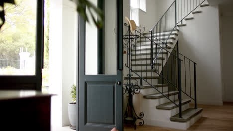 vista general de la escalera en el hogar con la puerta delantera abierta, cámara lenta