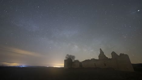 castillo y árbol sin hojas contra el cielo estrellado