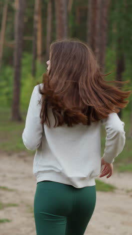 mujer corriendo en el bosque al crepúsculo de la noche. joven en ropa deportiva realiza actividad cardio intensiva en el aire fresco al atardecer. mejora de la salud física