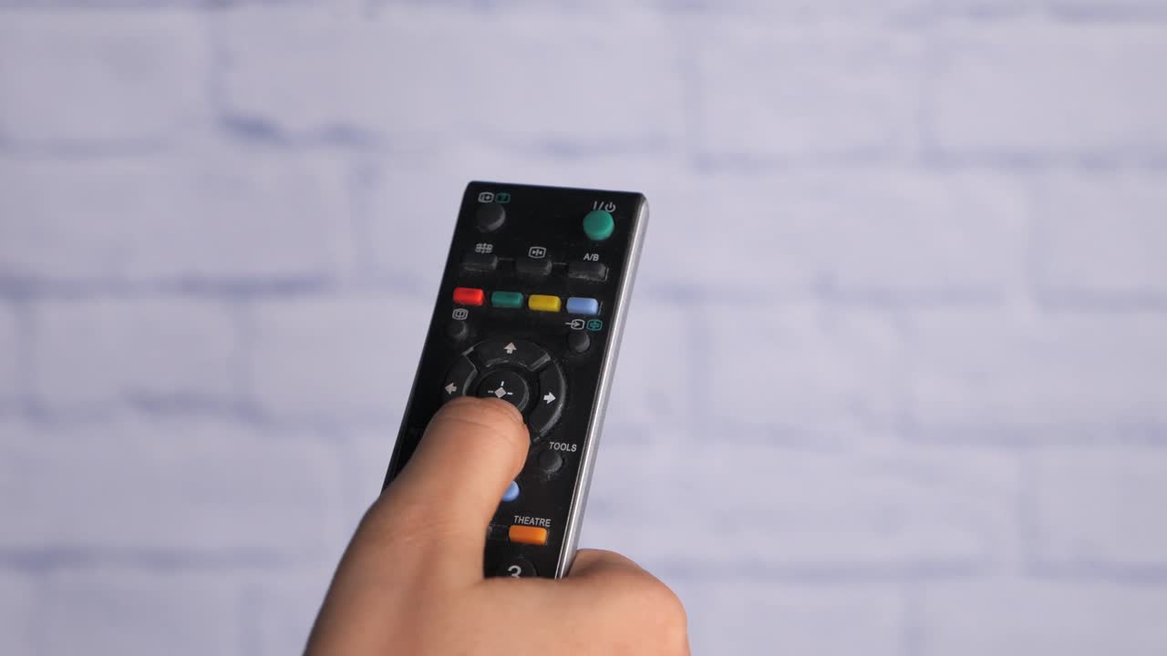 tv 리모컨을 들고 있는 손