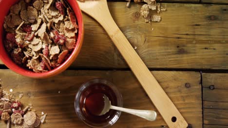 wheat flakes and honey on wooden table 4k