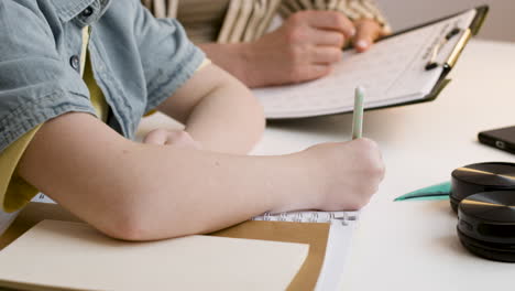 young teenager with golden bow doing maths with the help of her mom