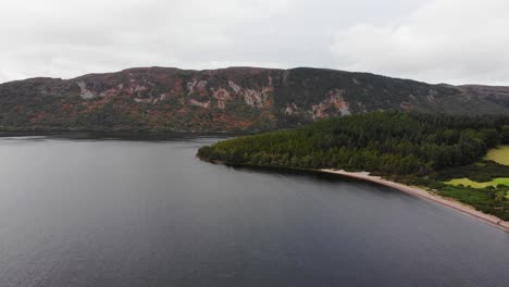 Luftaufnahme-Der-Strandküste-Am-Loch-Ness-Mit-Berglandschaft-Im-Hintergrund