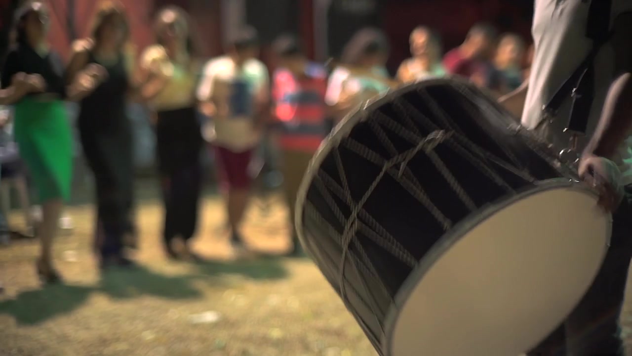 Musician Playing Traditional Drum at Outdoor Celebration